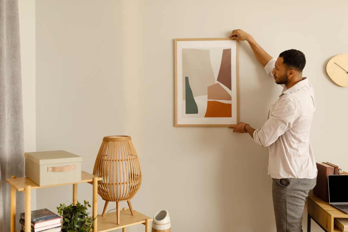 A Man Hanging a New Picture in His Office