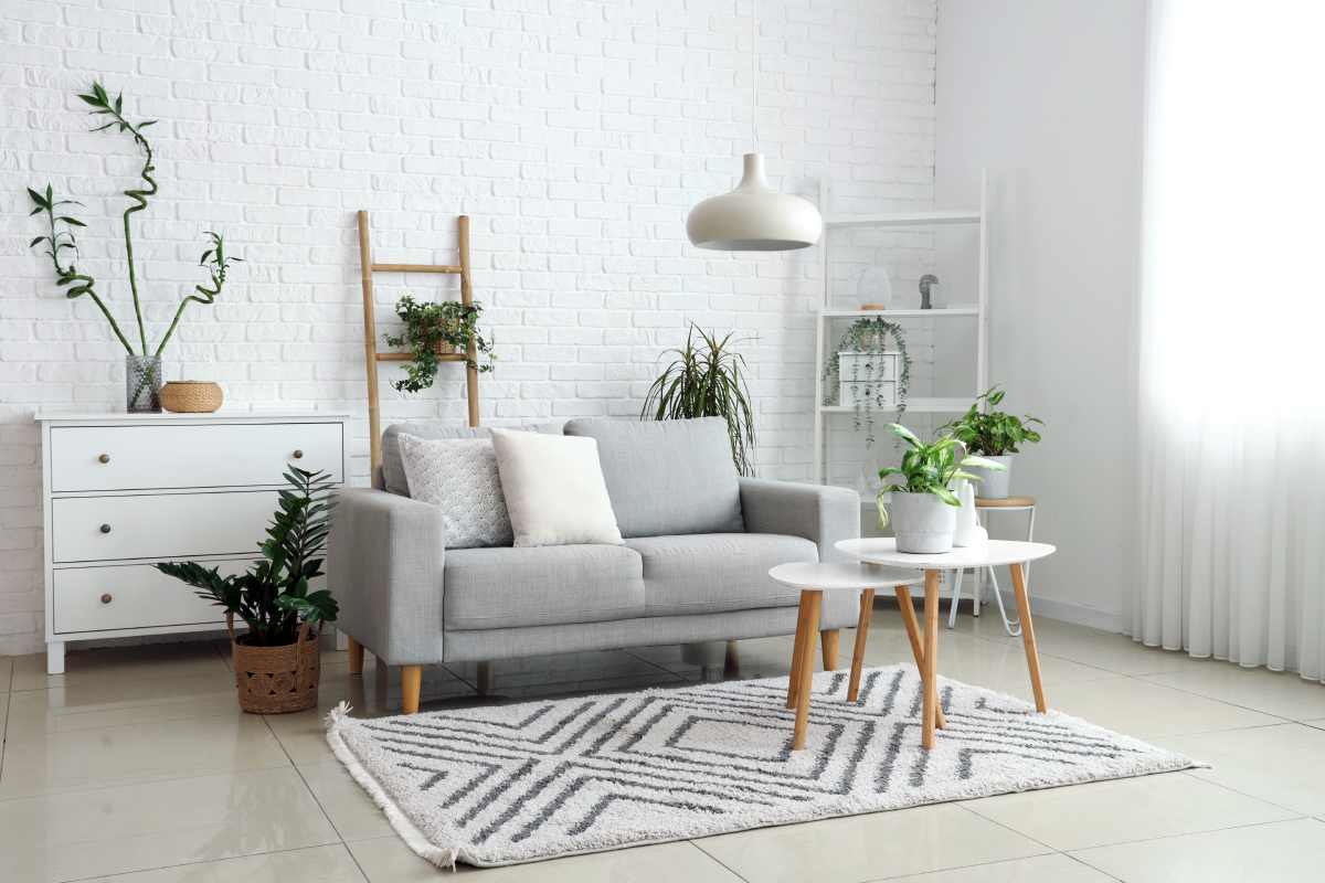 Gray Modern Couch in a Seating Area in Front of a Painted Brick Wall