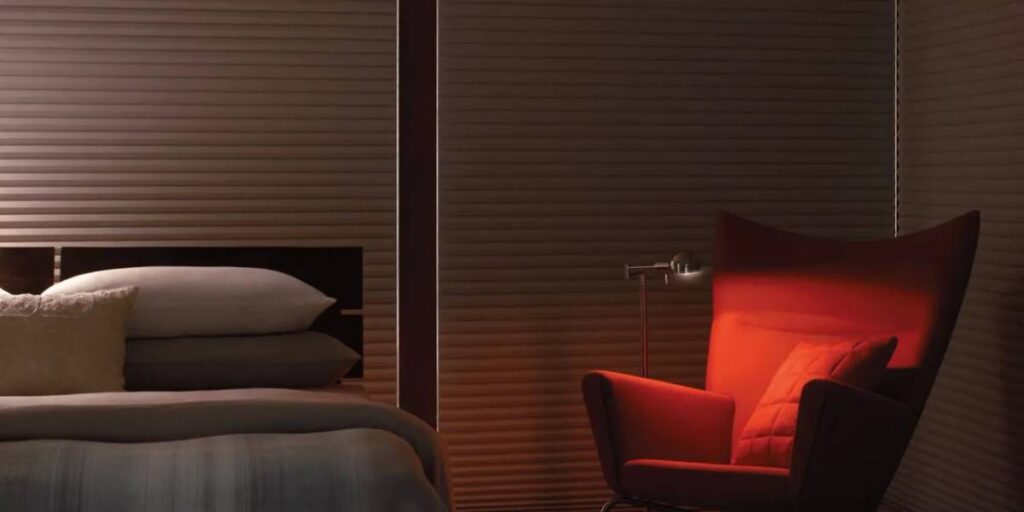 Hunter Douglas Duette® Cellular Shades Closed Behind a Bed and Arm Chair near New York City