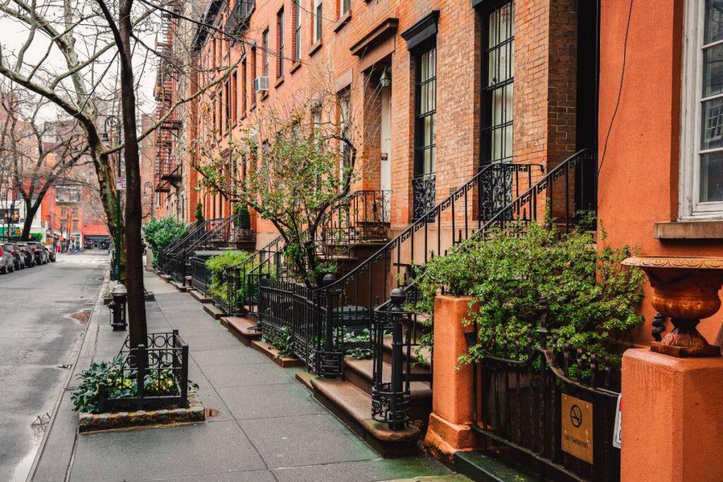 Historic buildings with fire escape ladders and parked cars in NYC